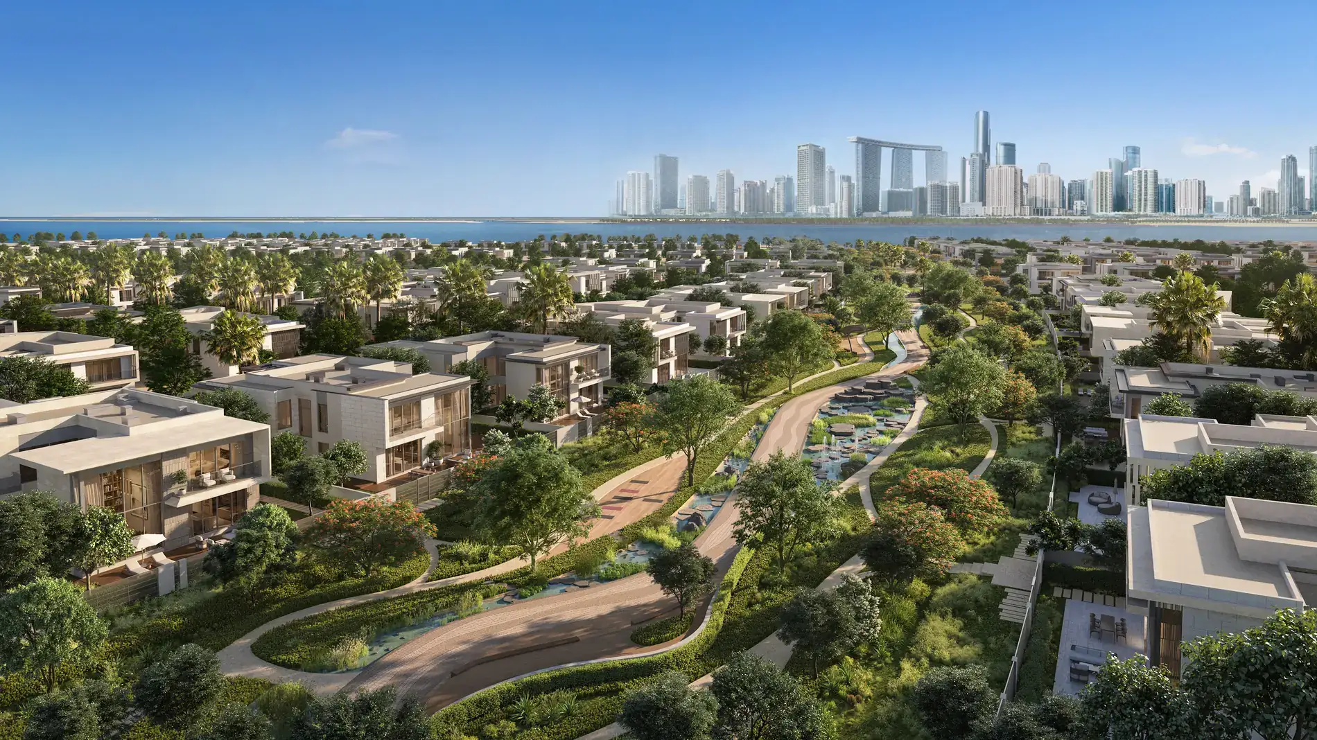 Talay Marsa Al Saadiyat — aerial view of the community: villas, the green spine with its water channel, the bay and the Abu Dhabi skyline beyond